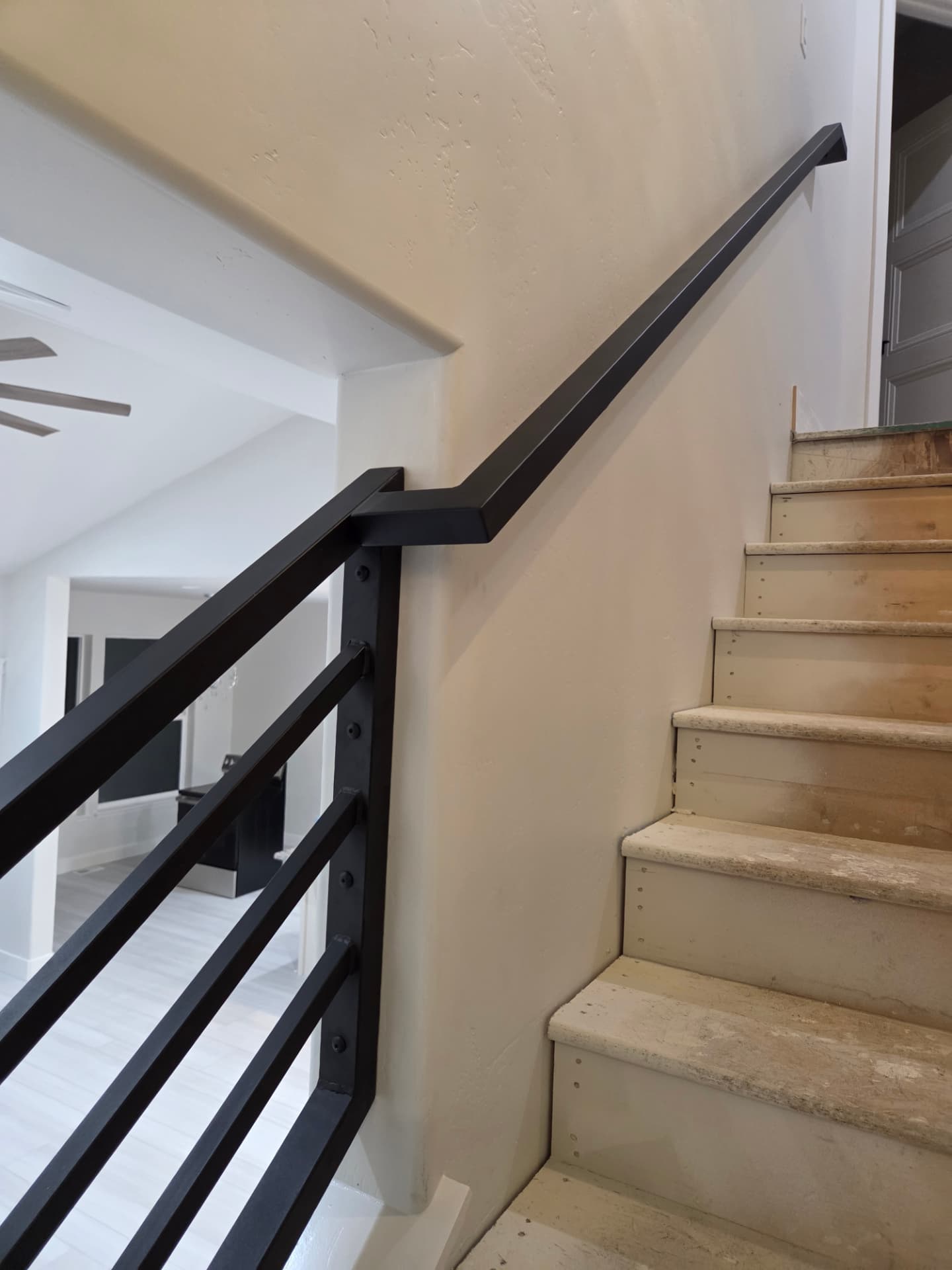 Black steel wall mounted handrail with matching stair guardrail