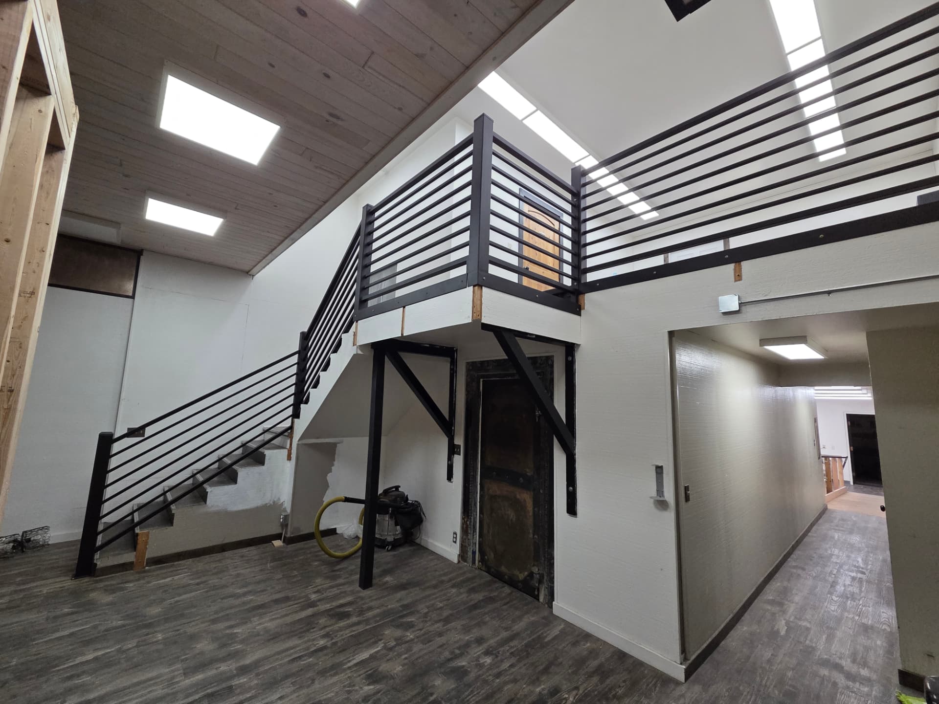 Black steel mezzanine guardrail and stair railing in a commercial interior