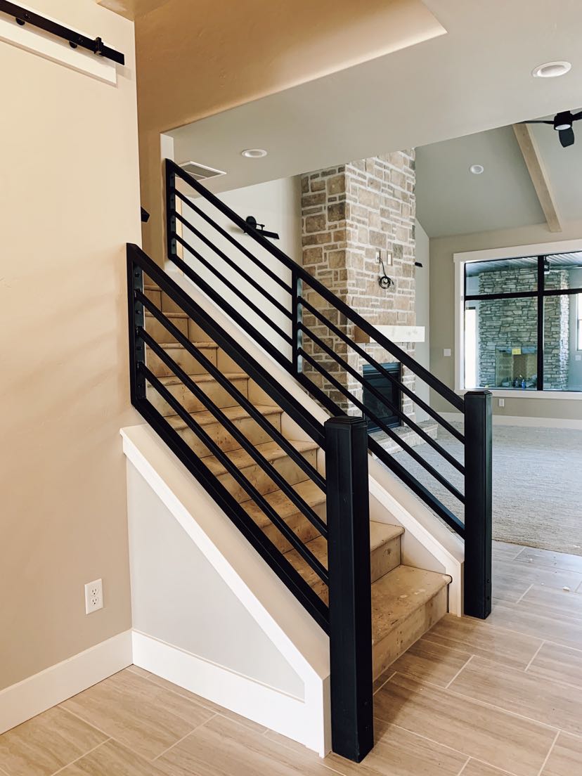 Black steel horizontal bar stair railing in an open concept home