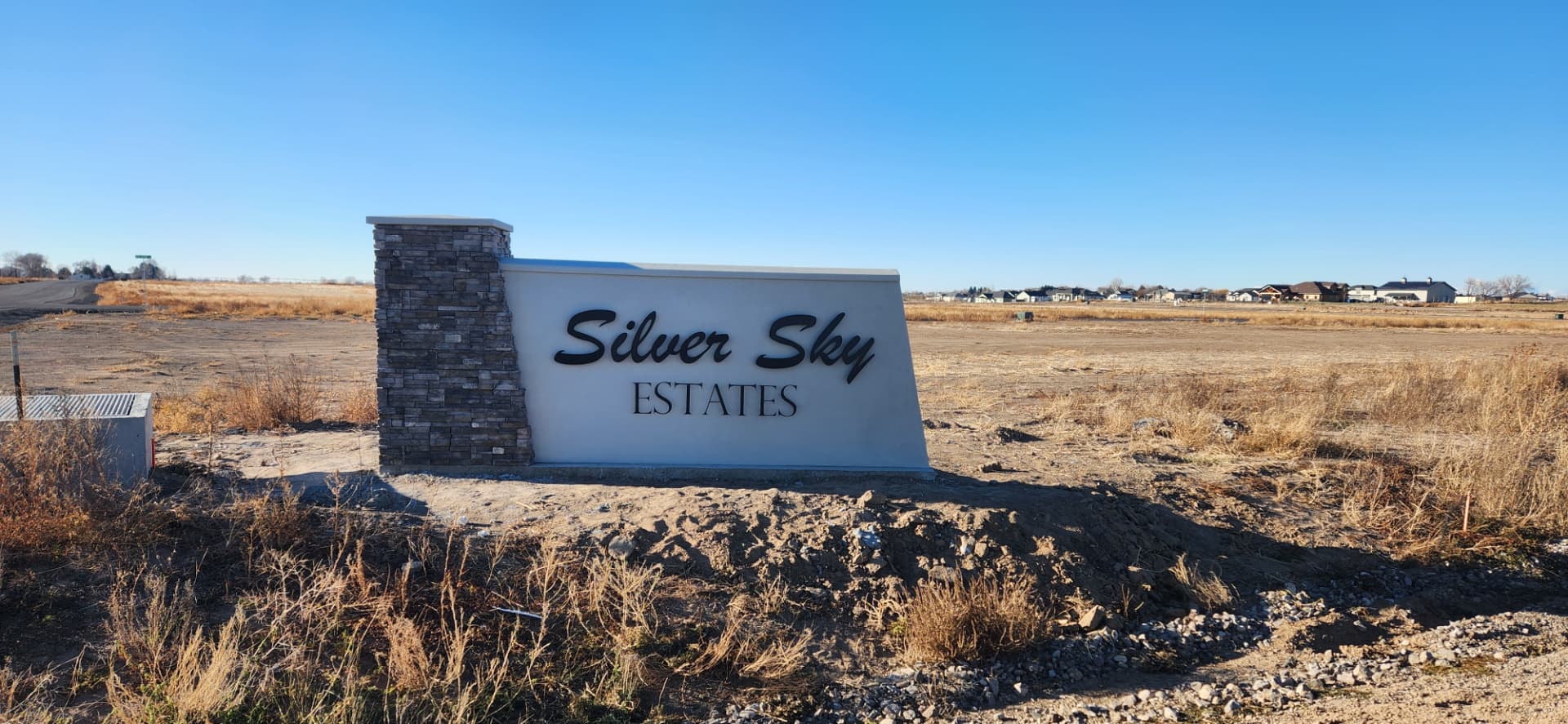Black metal script lettering mounted on a subdivision entry monument