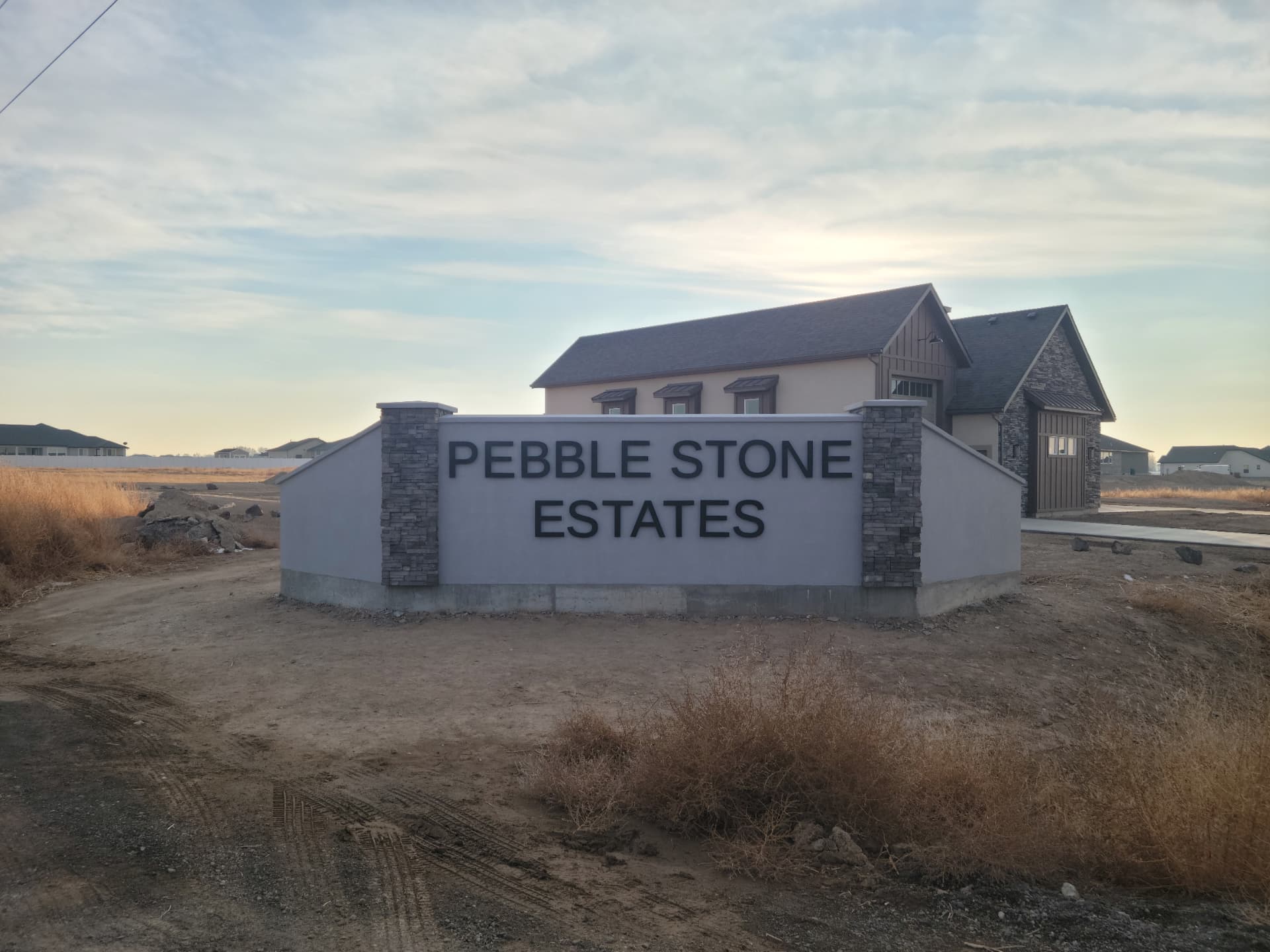 Cut metal lettering mounted on a stucco subdivision entry monument sign