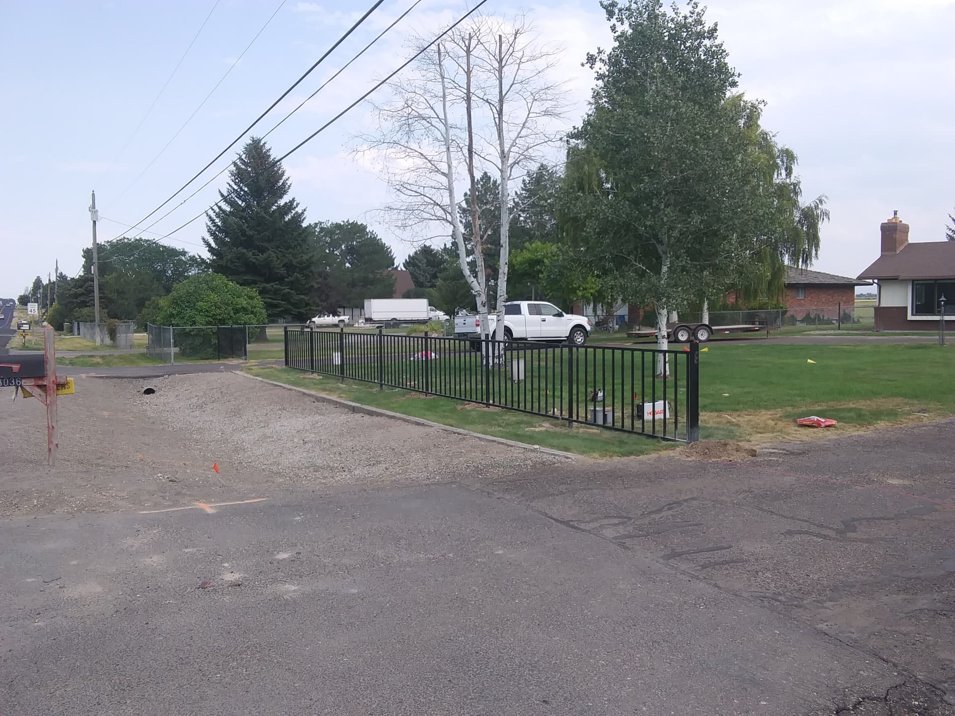 Black steel picket fence line along a residential yard