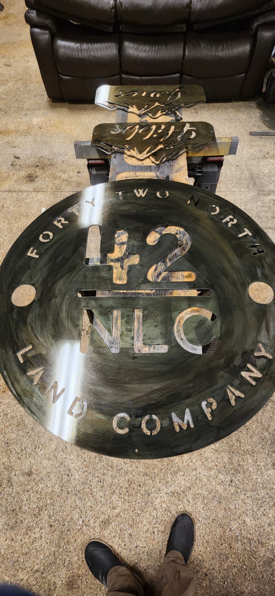 Large round plasma cut steel company medallion sign in the shop