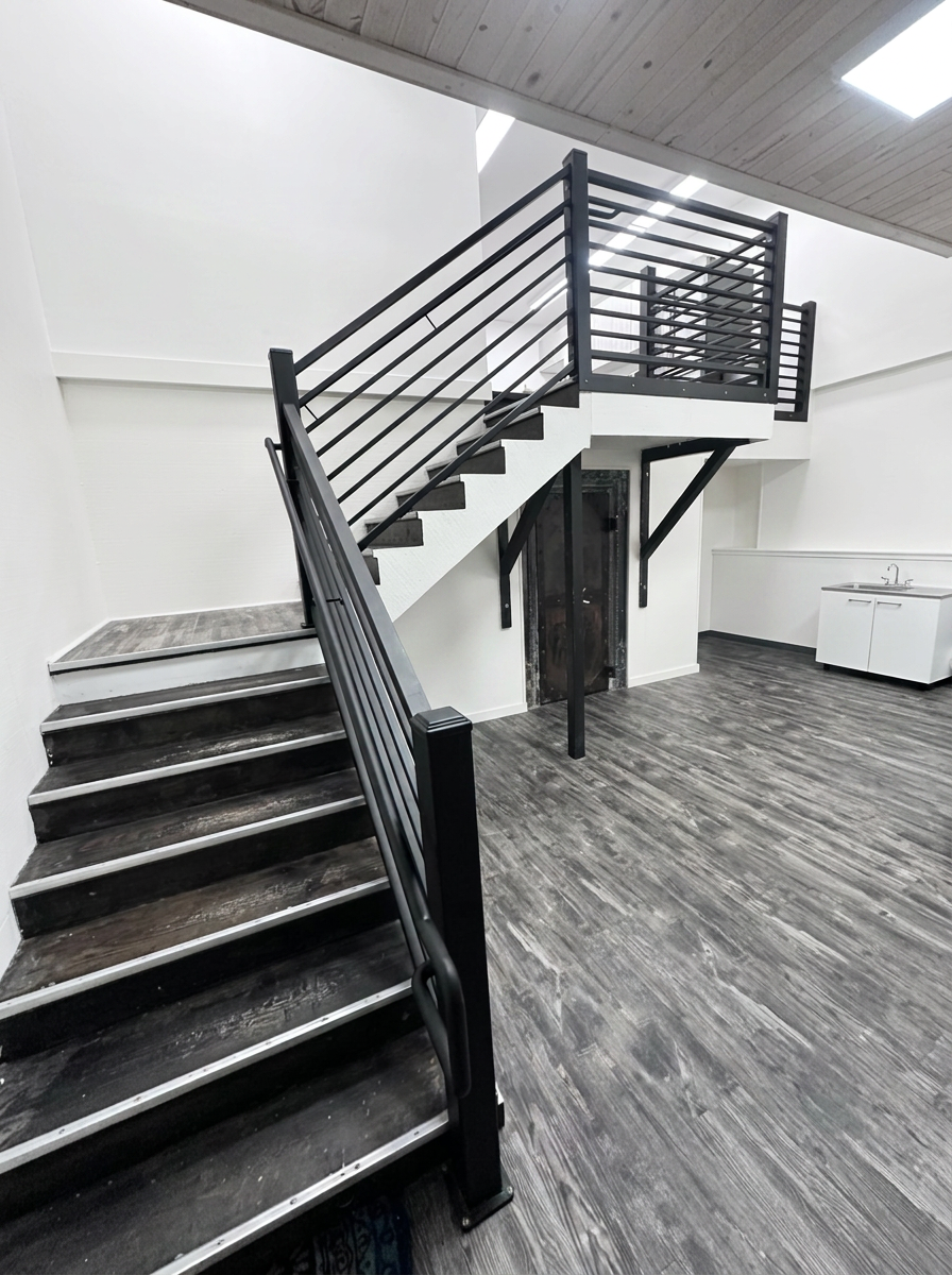 Custom black steel stair railing and mezzanine guardrail with horizontal bars
